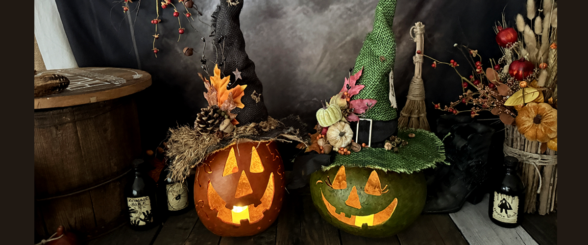 Handcrafted orange and green extra-large gourd pumpkins with glowing carved faces and custom witch hats