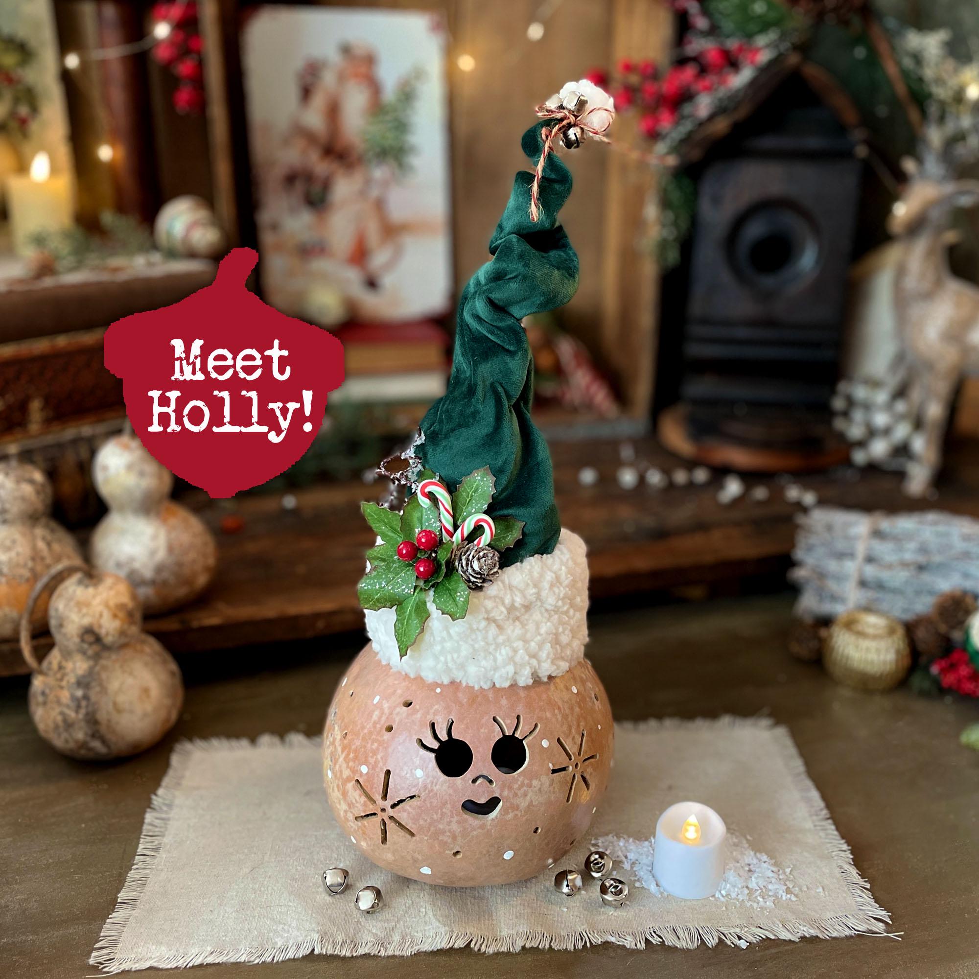 Decorative Christmas lantern with a face, surrounded by festive decorations, on a wooden surface.