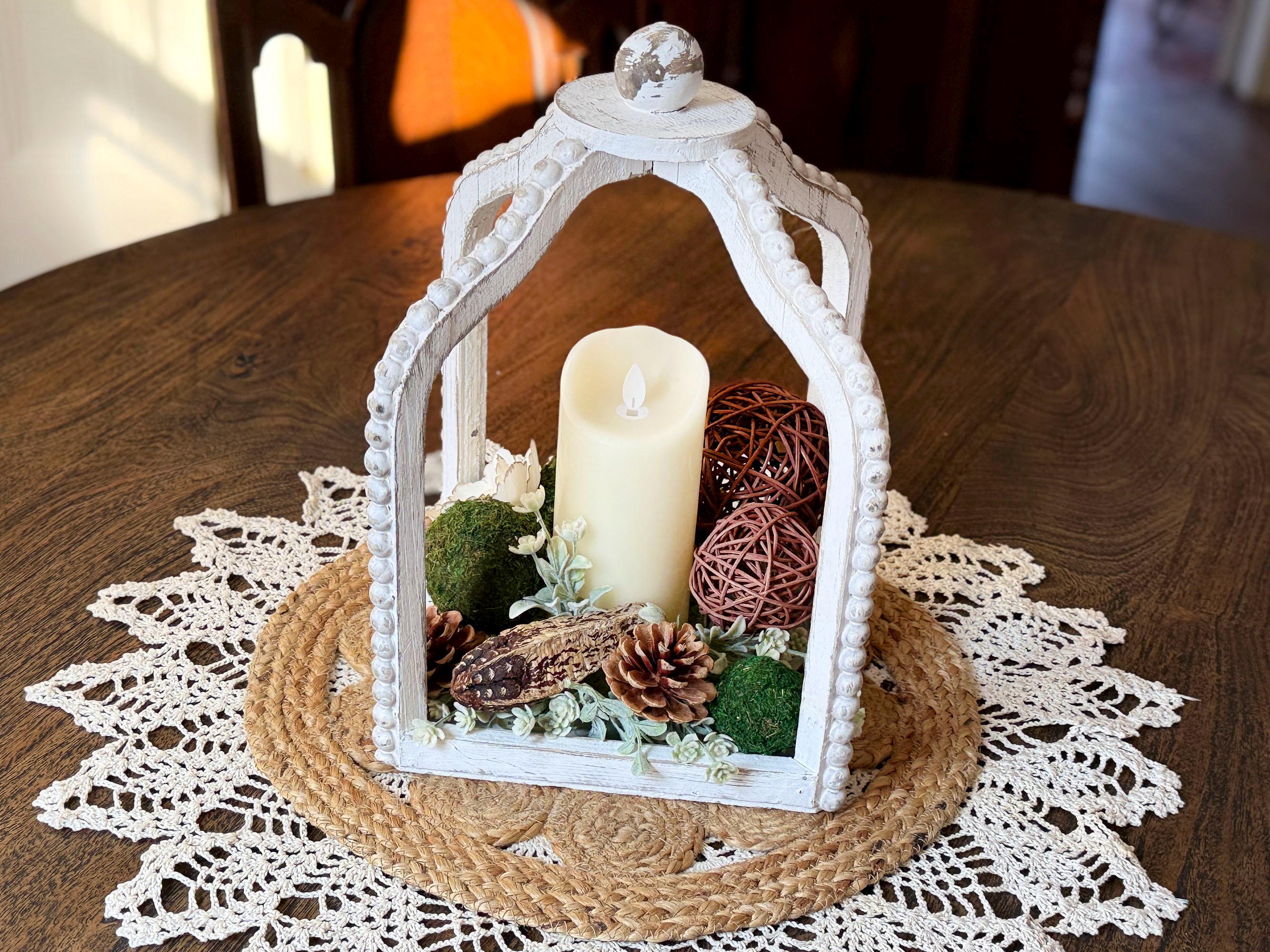 Decorative lantern with a candle on a wooden table with a lace doily