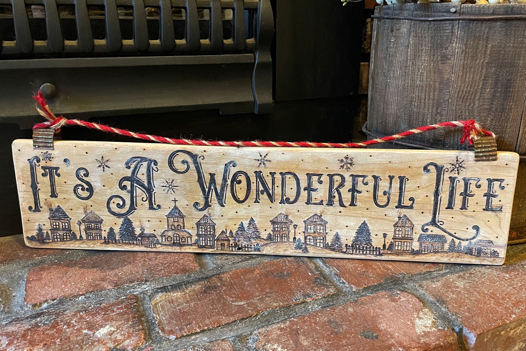 Wooden sign with 'It's a Wonderful Life' text on a brick surface