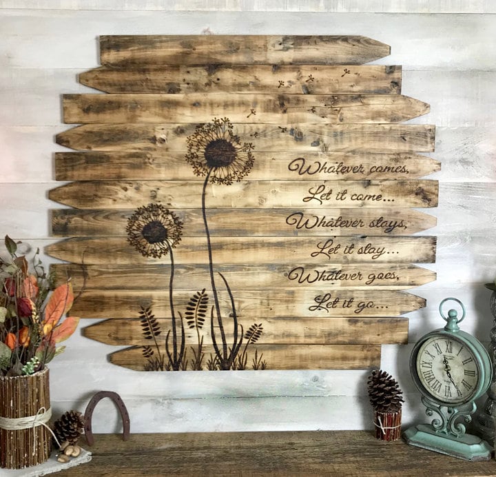 Wooden wall art with dandelion design and motivational quote on a rustic background.