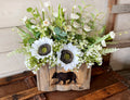 Floral arrangement in a wooden box with bear design on a rustic wooden surface.