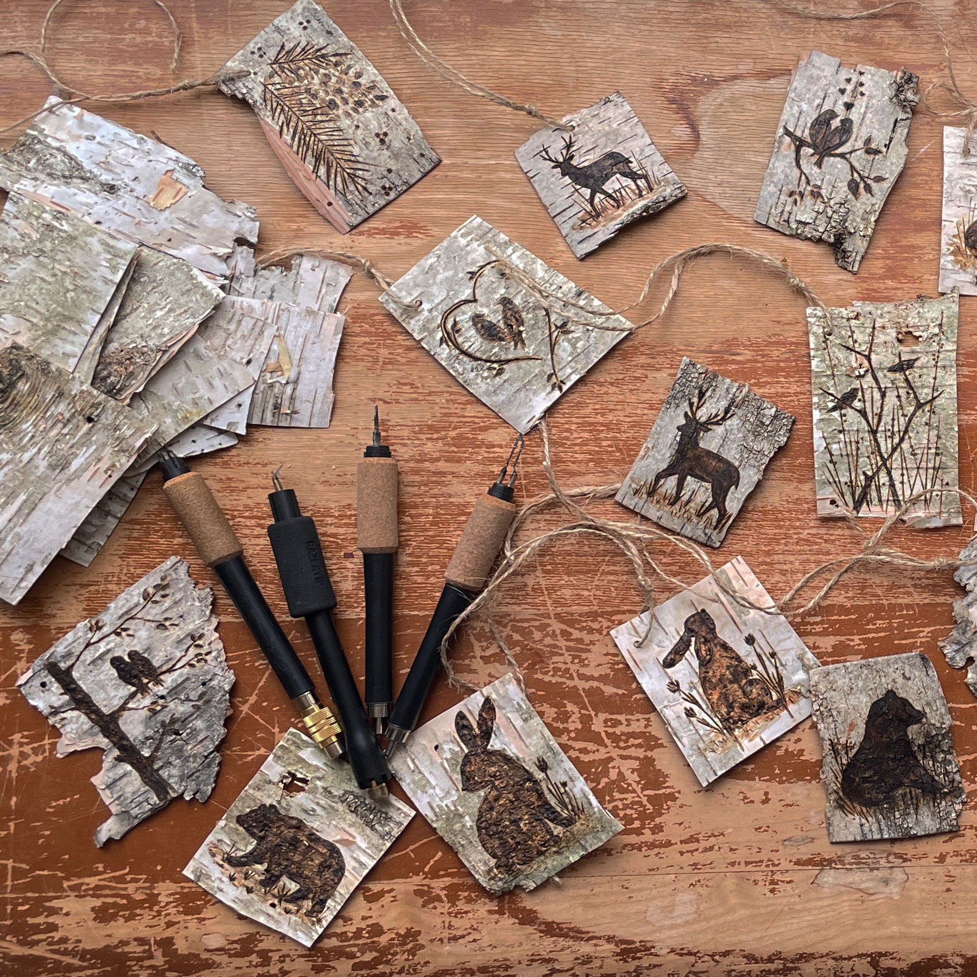 Decorative birch bark tags with animal-themed artwork.
