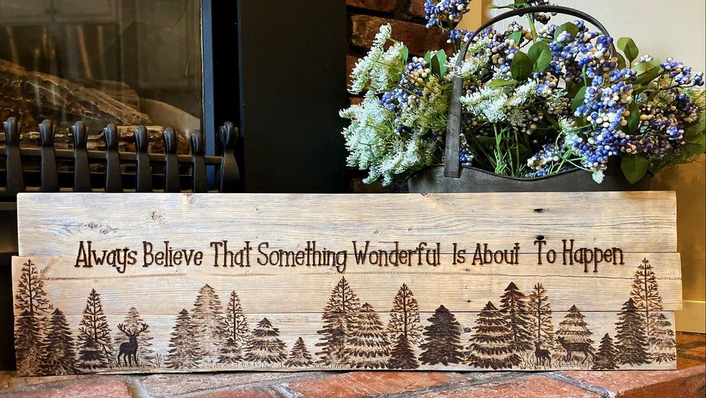 Wooden sign with nature design and text on a brick surface, with flowers in the background.
