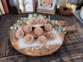Wooden tray with decorative wood flowers on a rustic wooden surface