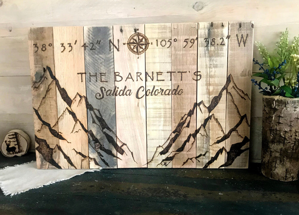 Personalized wooden sign with mountains and coordinates, featuring the text 'The Barnetts Salida Colorado'.