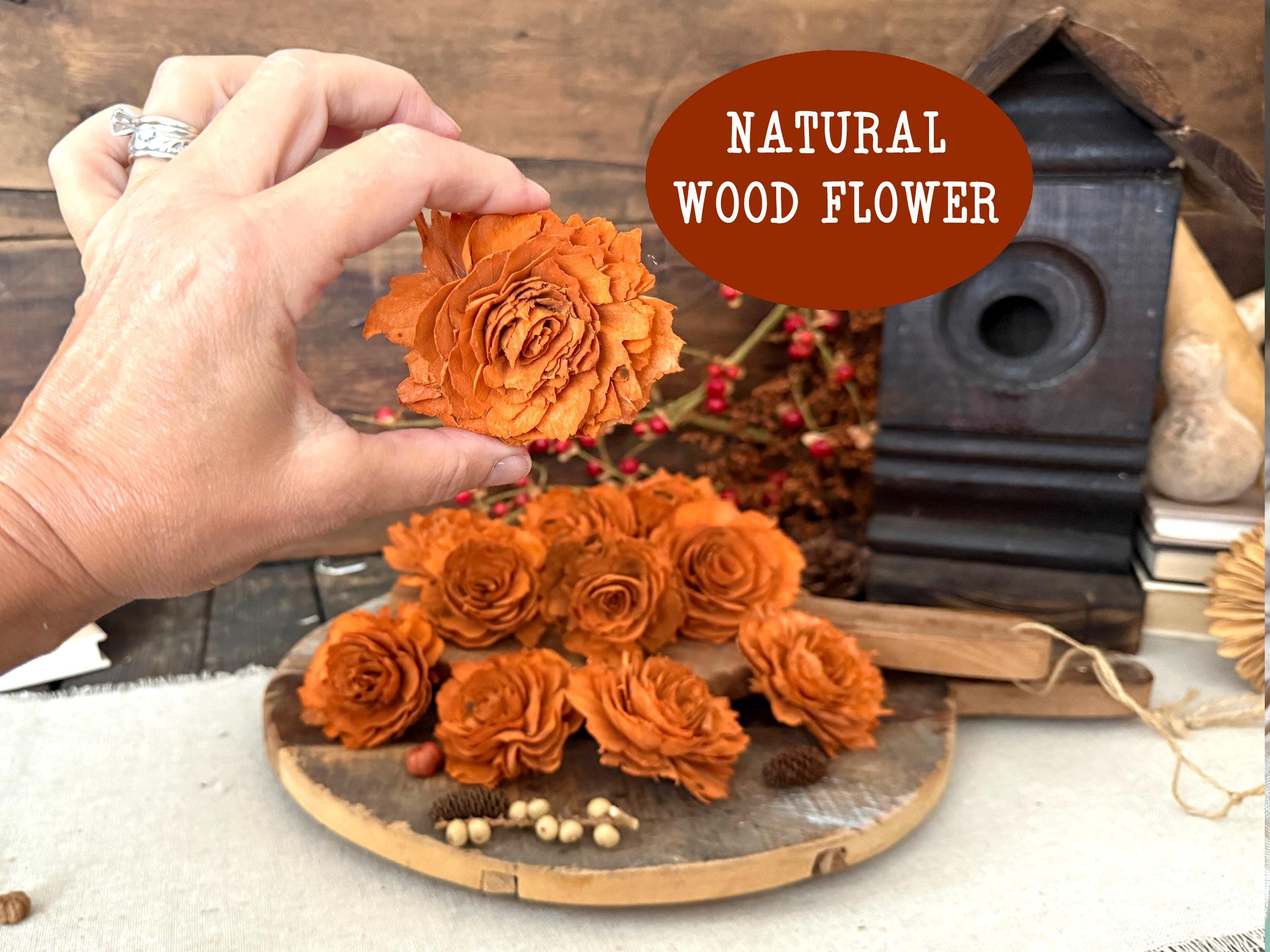 Hand holding a natural wood flower with a rustic background