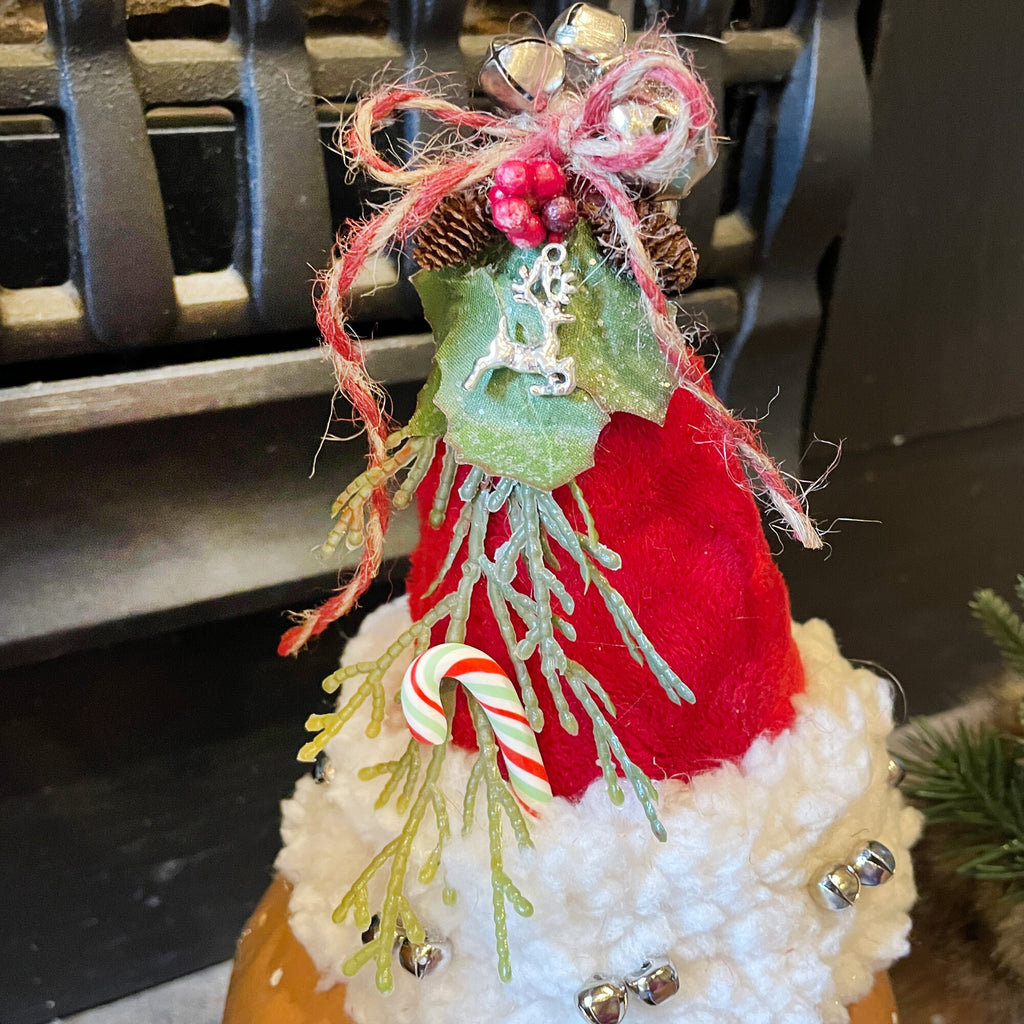 Decorative Christmas tree with red hat, candy cane, and festive decorations on a dark background.