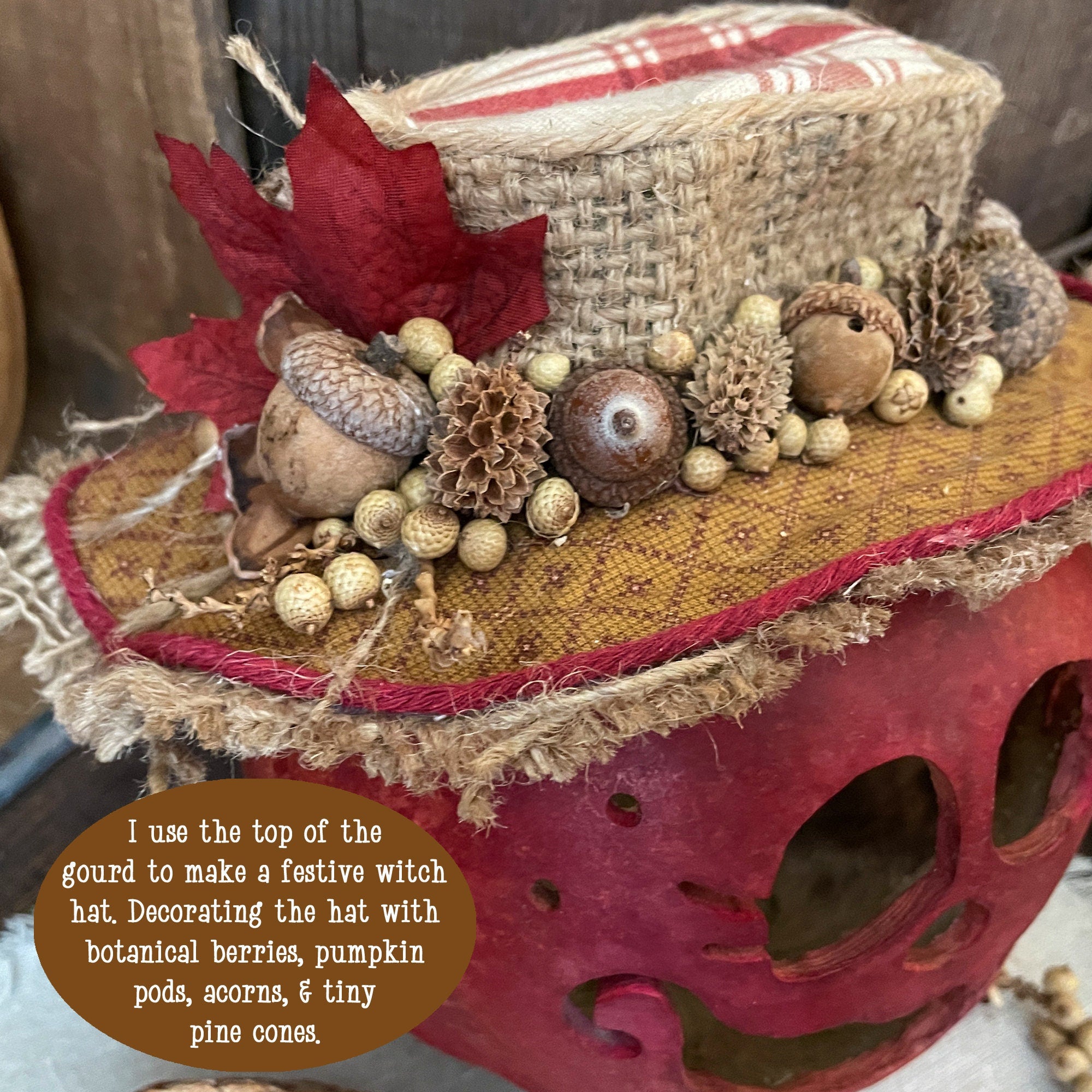 Decorative witch hat with autumn elements on a red skull, featuring text about its use.