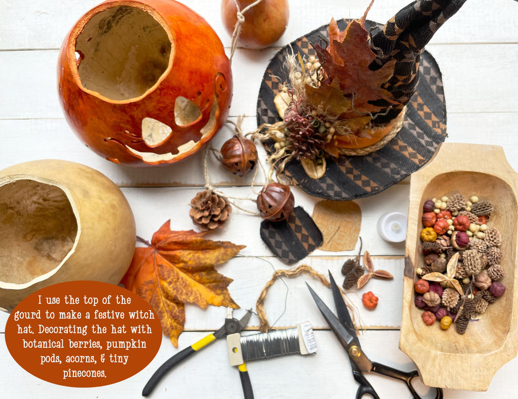 Decorative items including a carved pumpkin, acorns, pinecones, and a wooden bowl on a white surface.