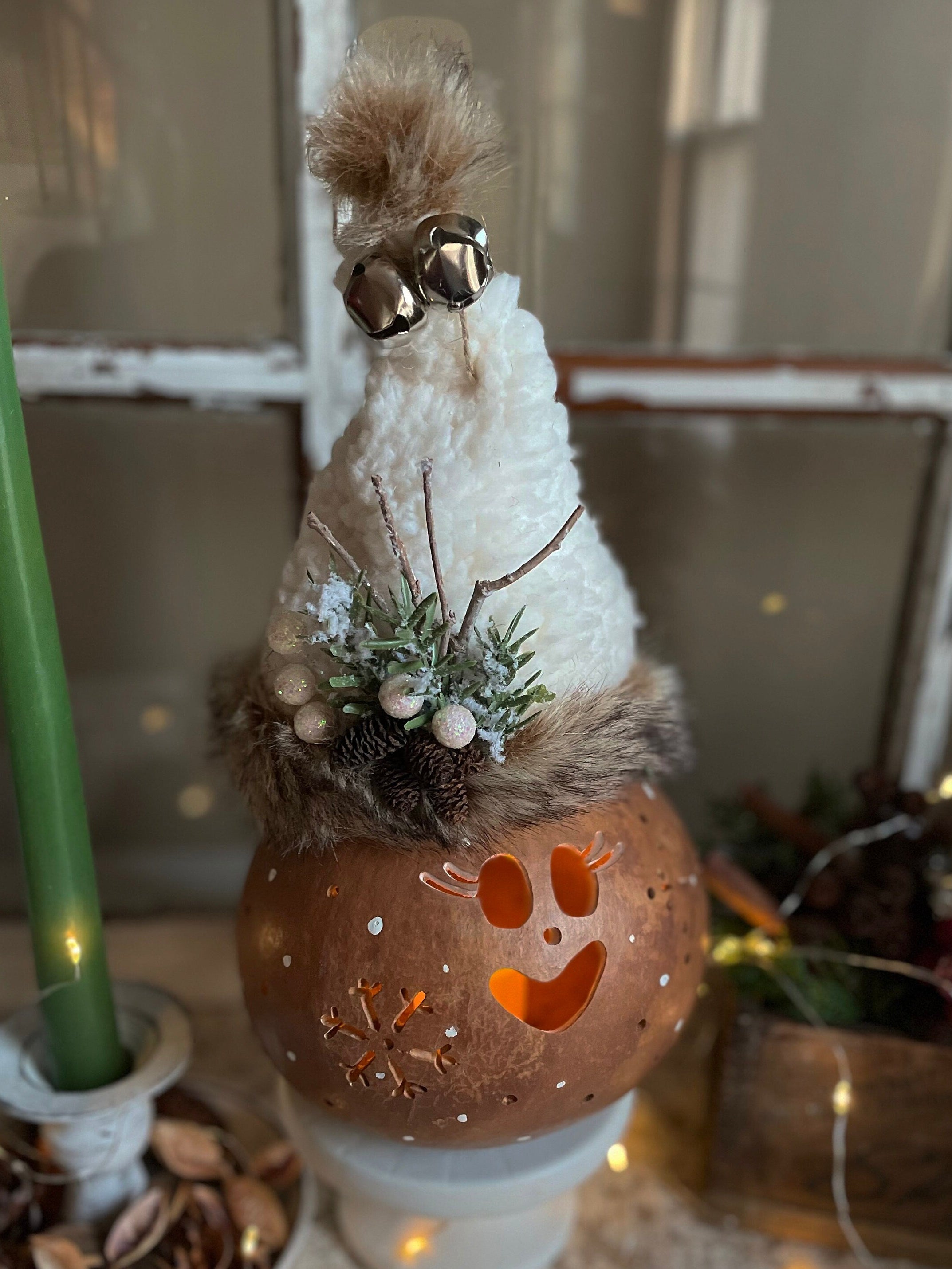 Decorative autumn-themed topiary with pumpkin base, white sphere, and fur accents.