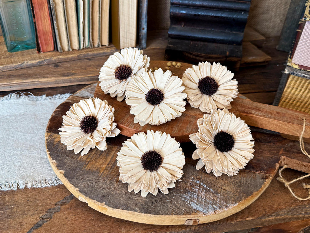 Decorative white flowers with brown centers on a wooden surface.