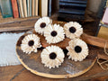 Decorative white flowers with brown centers on a wooden surface.