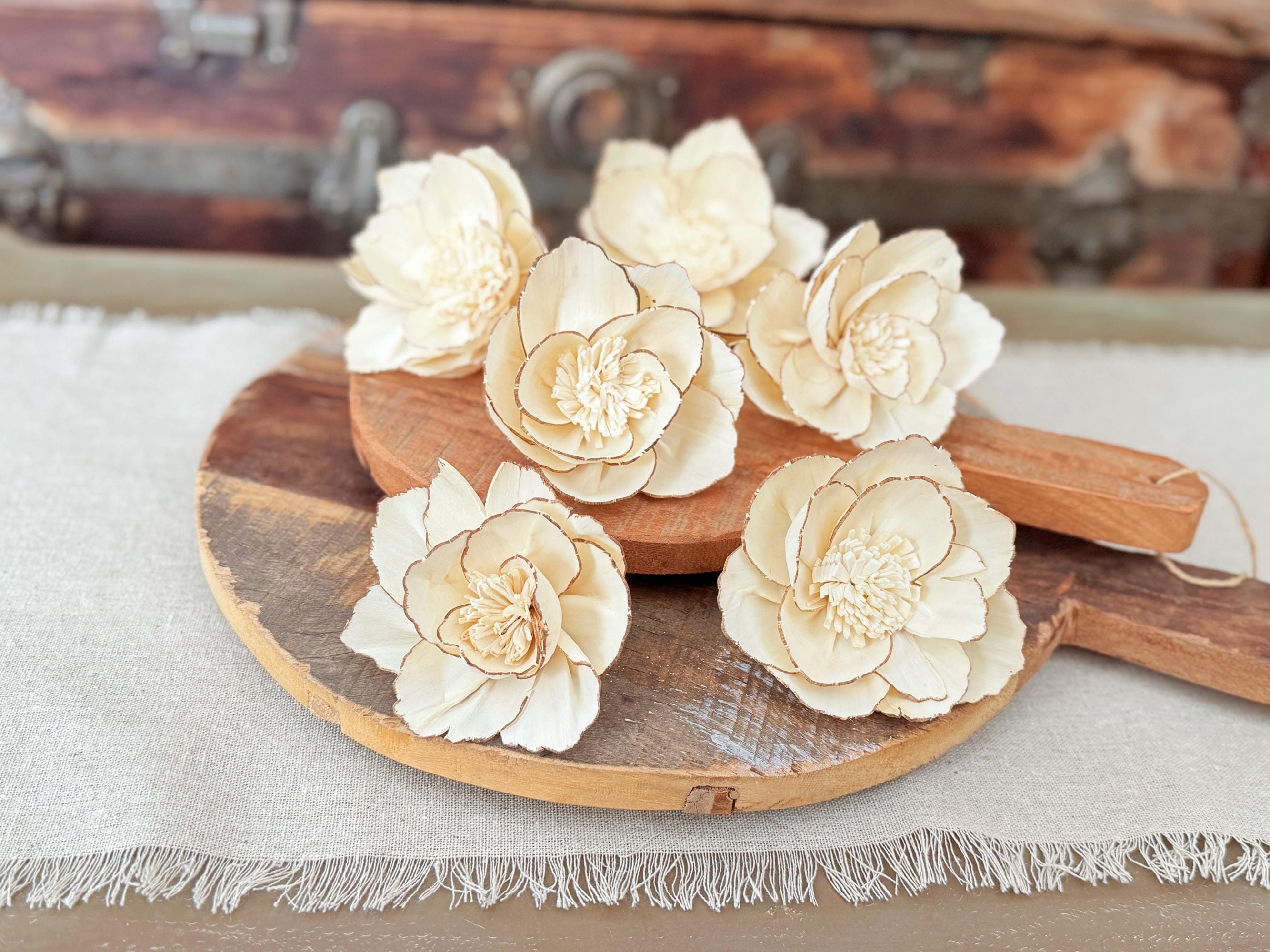 Wooden paddle with beige floral decorations on a textured surface