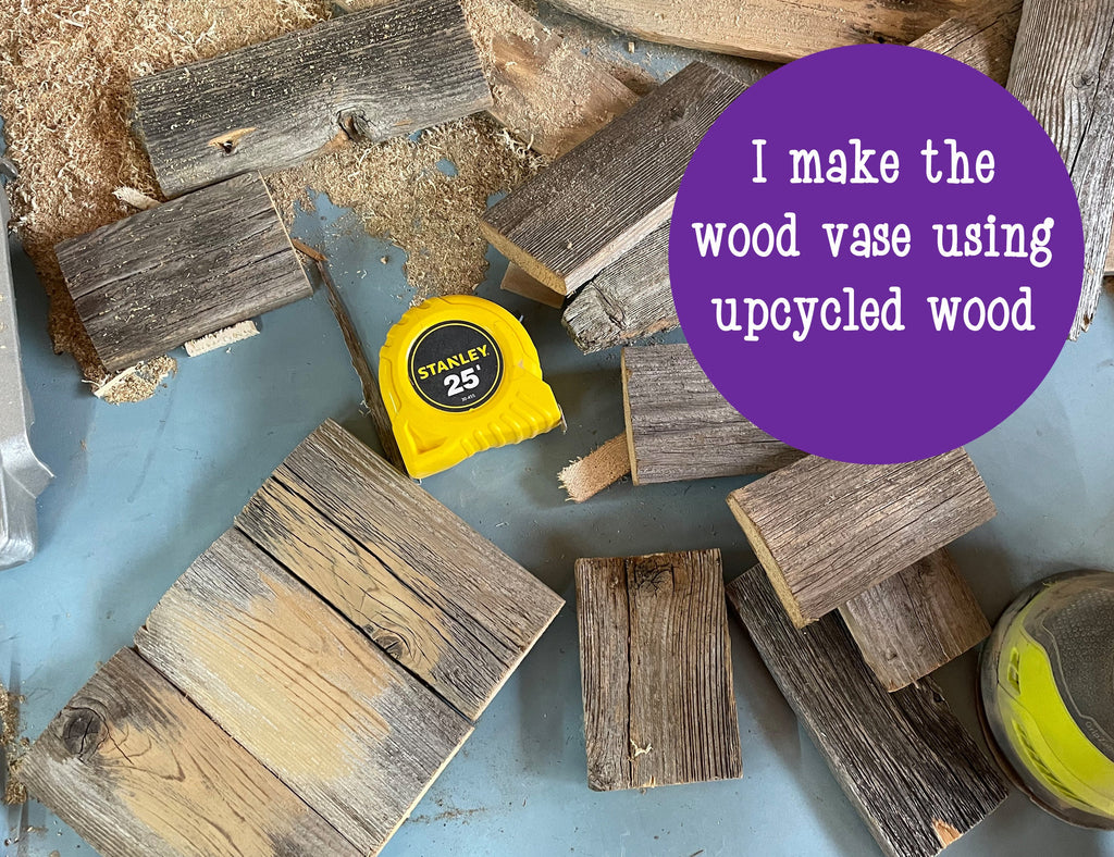 Wooden planks and a Stanley tape measure on a blue surface with text about upcycled wood vase.
