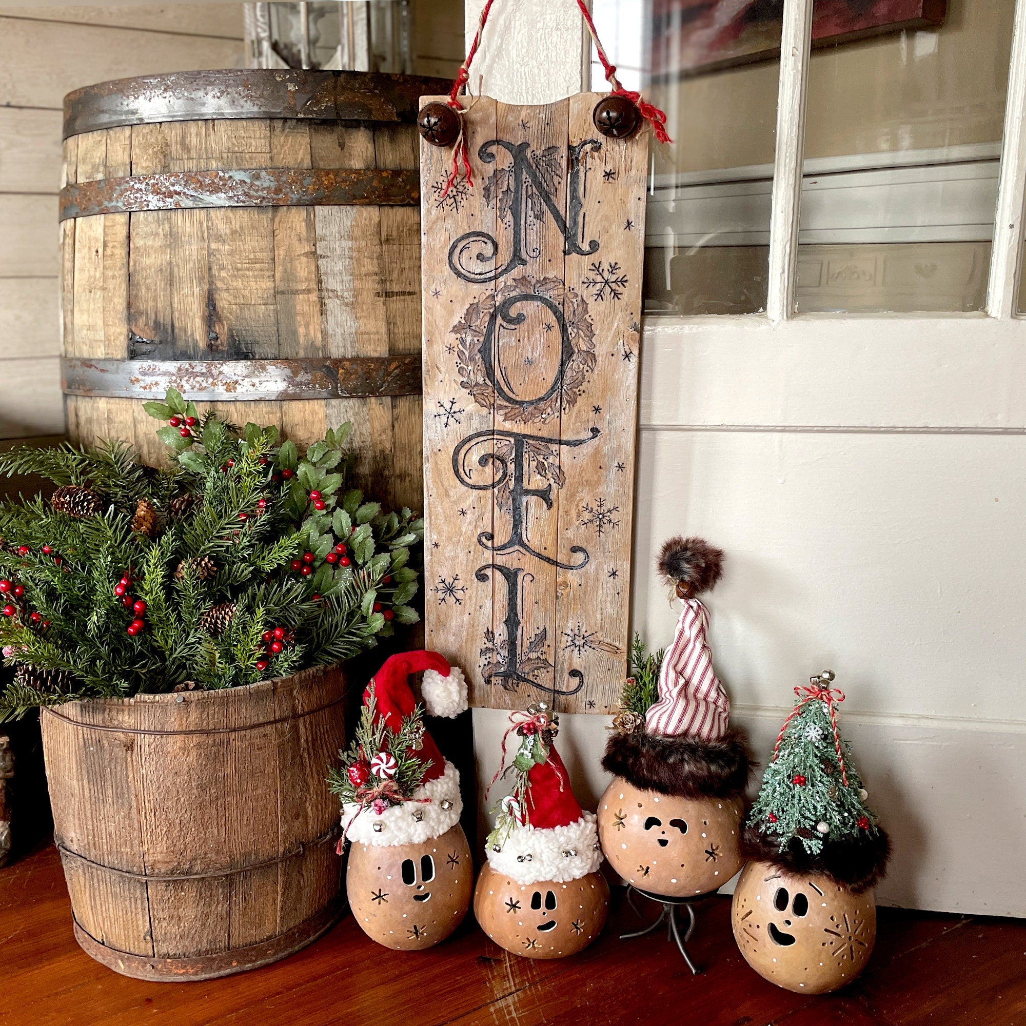 Decorative setup with 'NOEL' sign, Christmas-themed decorations, and potted plant.
