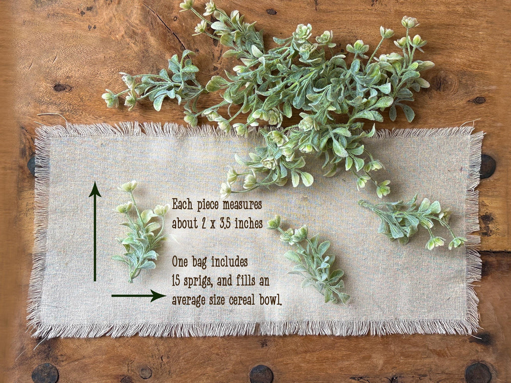 Greenery on a piece of fabric with measurements on a wooden surface