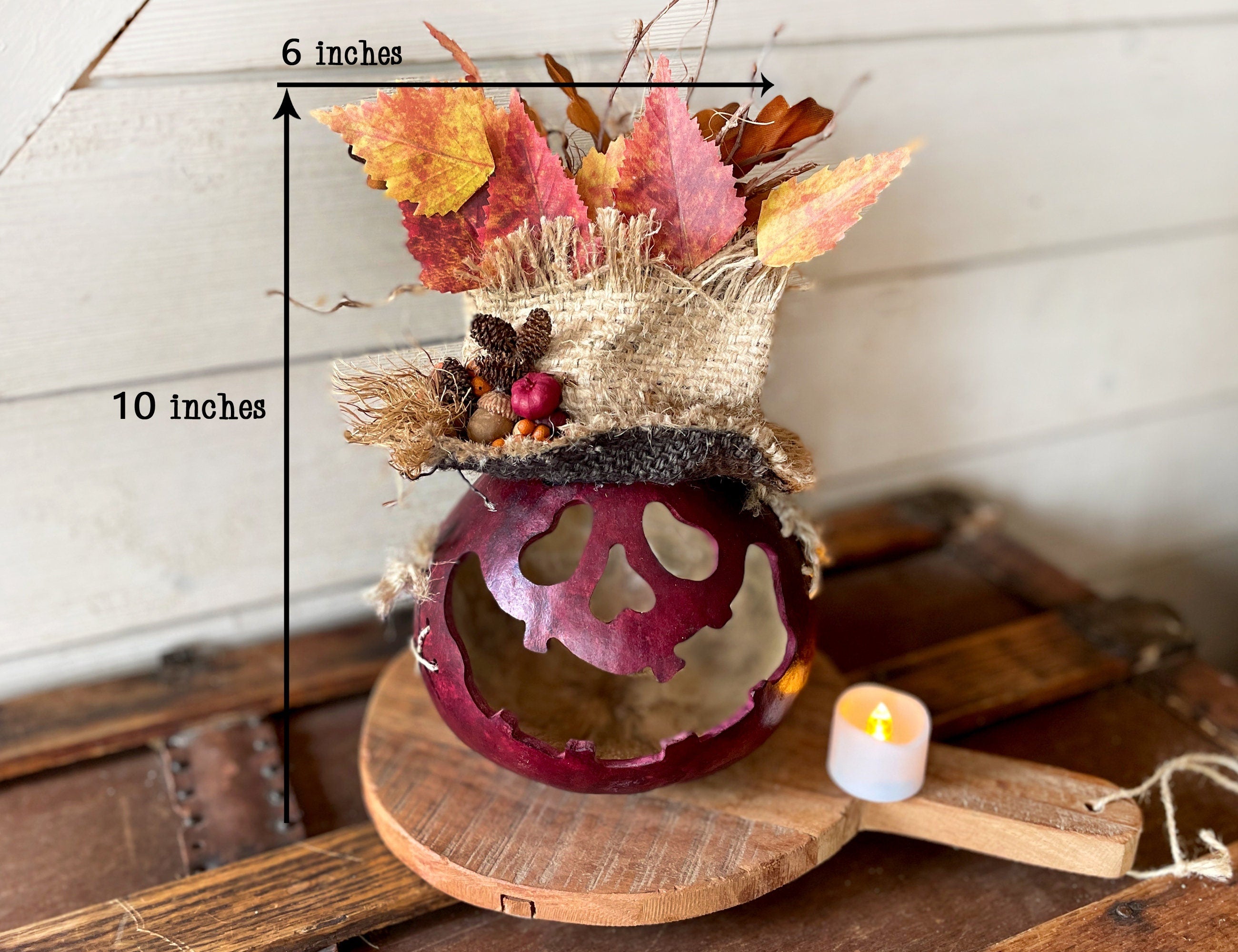 Decorative item with autumn leaves and a candle on a wooden surface