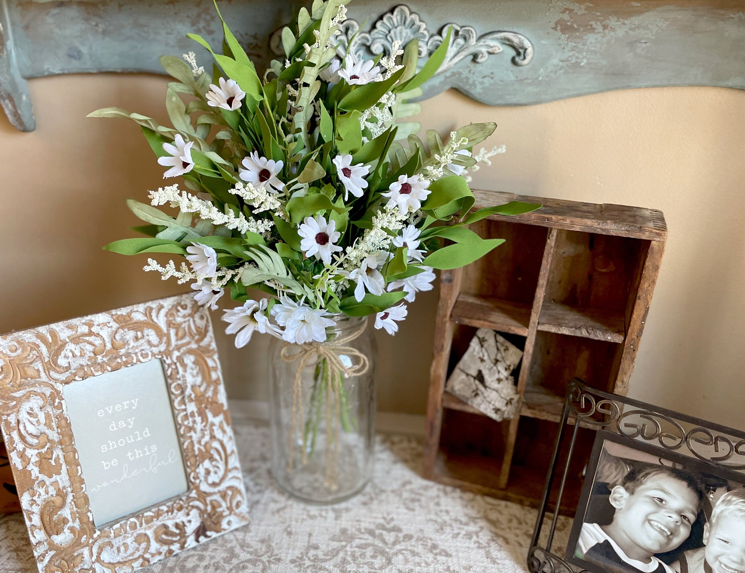 Bouquet of flowers in a vase with decorative frames on a surface.