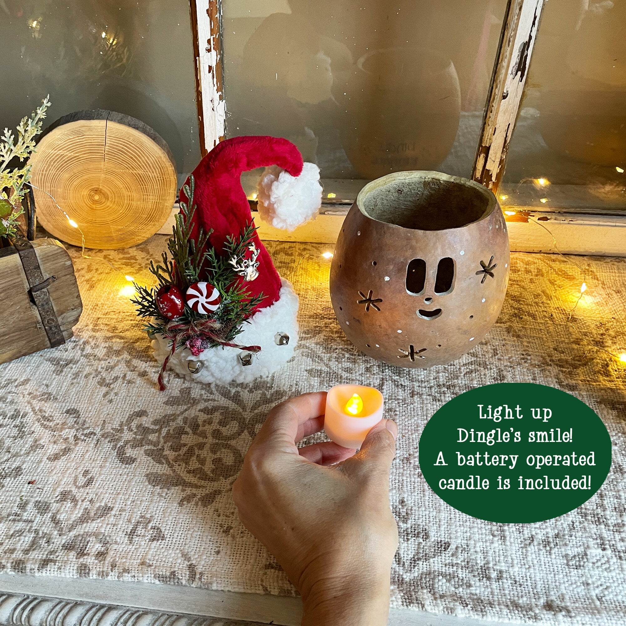 Decorative setup with a small Santa Claus figure, candle holder, and battery-operated candle on a textured surface.