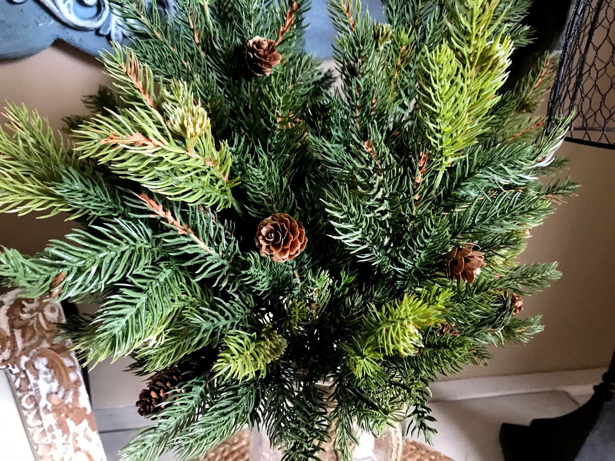Decorative wreath with greenery and pinecones on a door