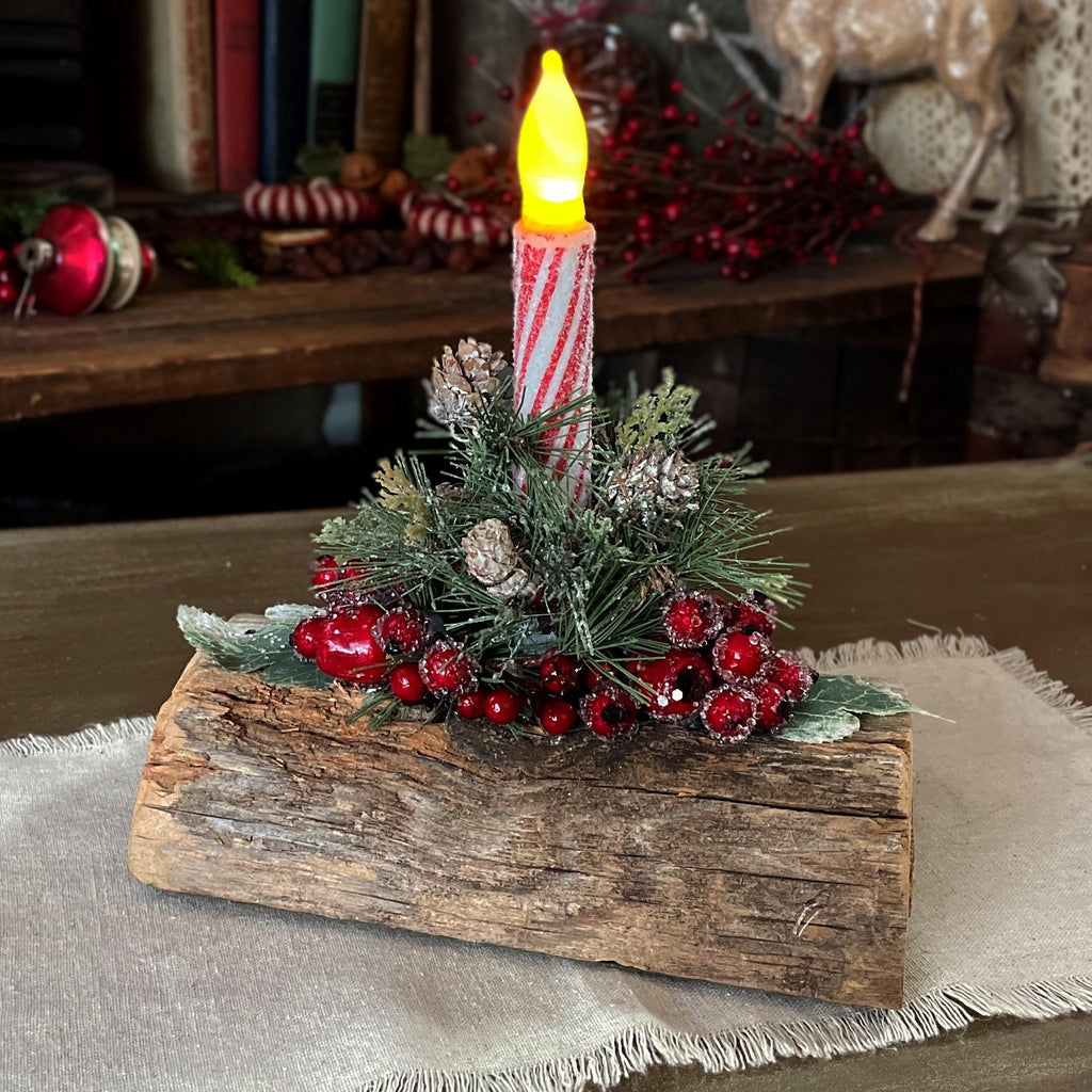 Decorative candle on a wooden base with festive elements in a home setting