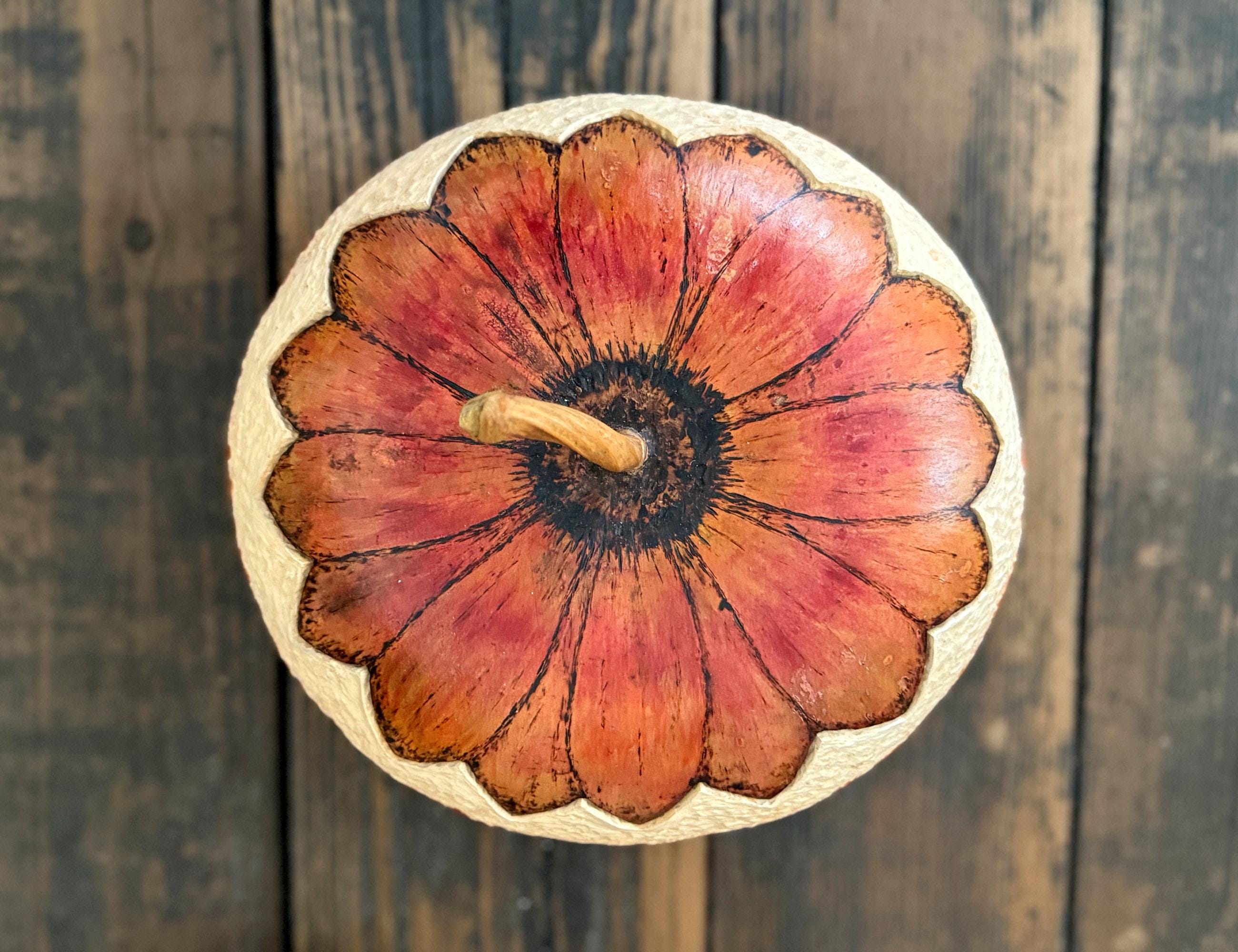 Decorative gourd with floral design on a wooden surface