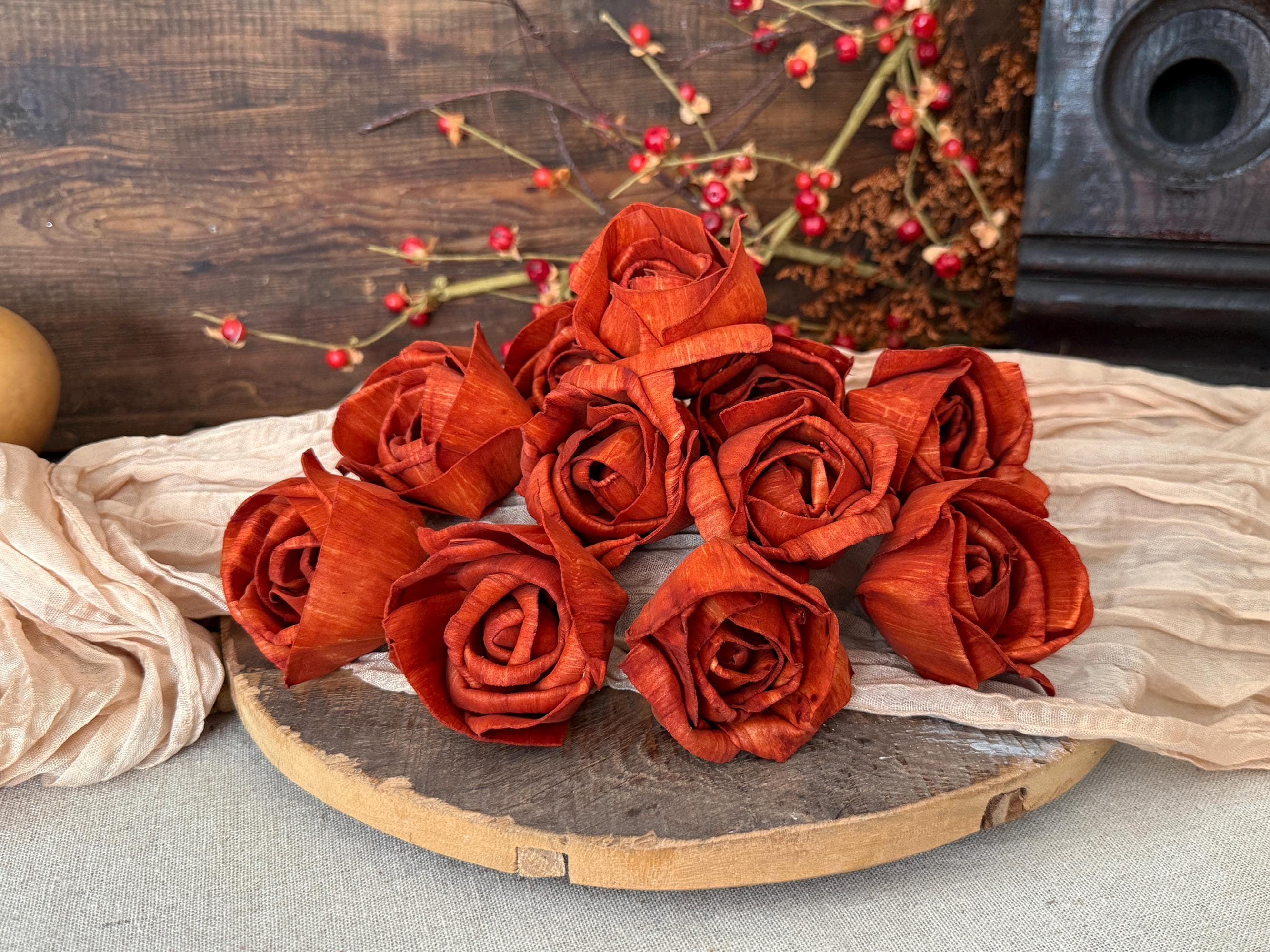 several orange roses laid out on a wooden surface with a rustic background.