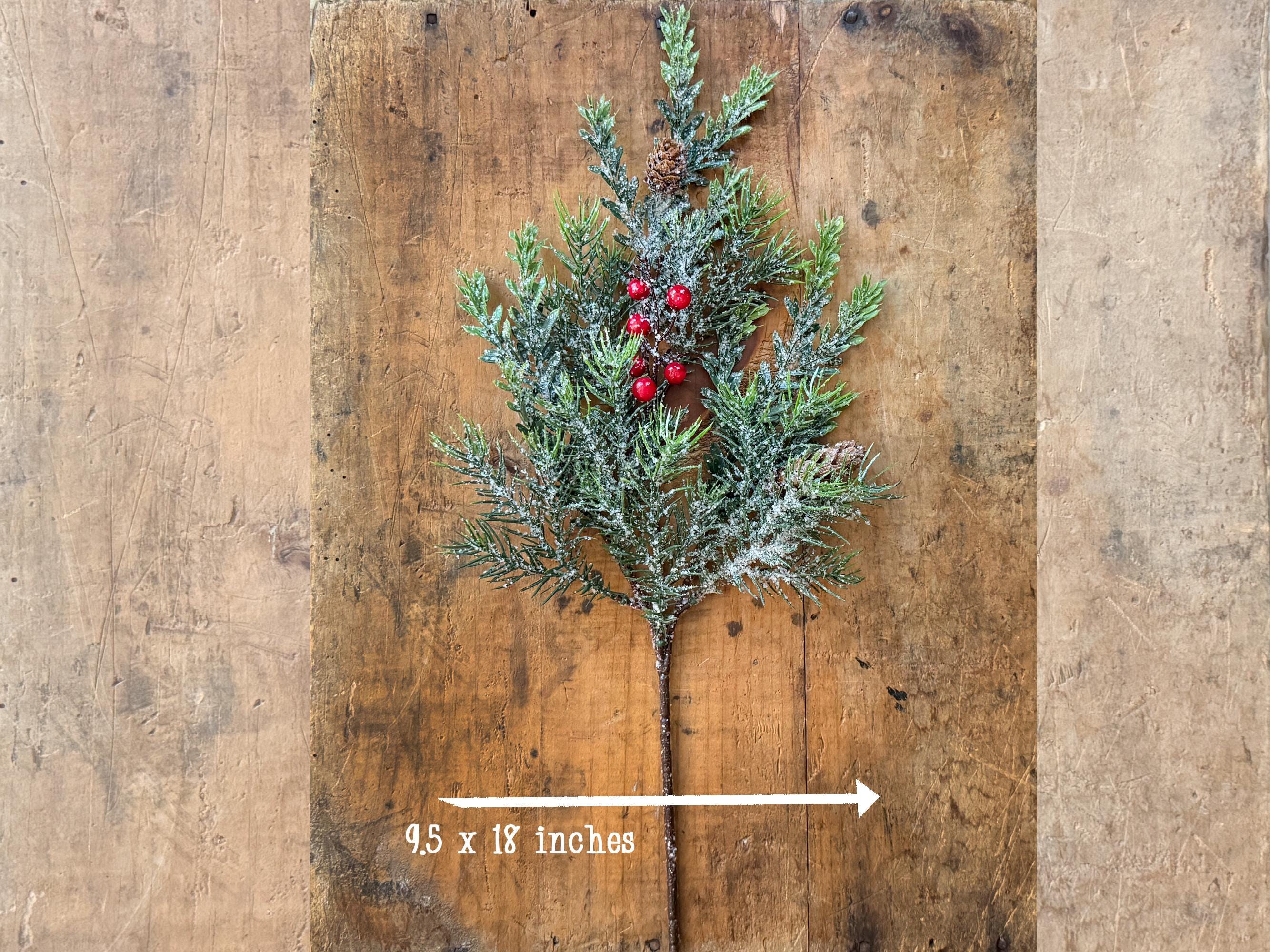 Artificial Christmas tree branch with red berries on a wooden background