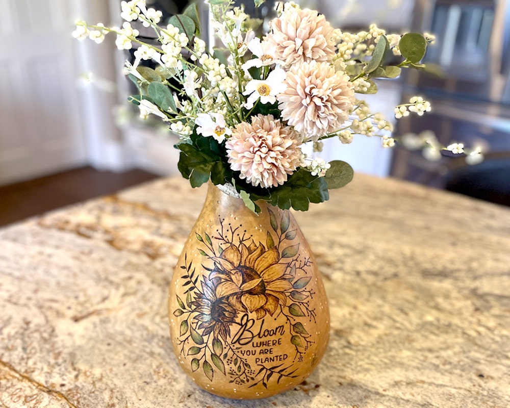 Decorative gourd vase with floral arrangement on a table