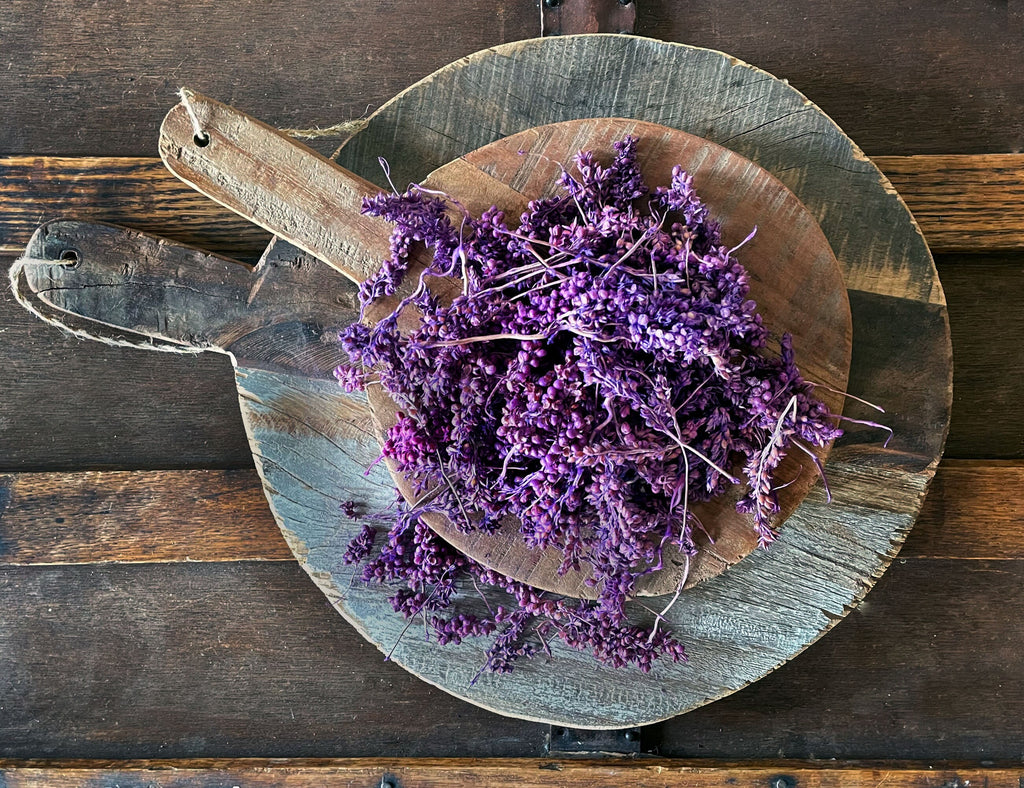 Purple flowers on a wooden board against a rustic wooden background