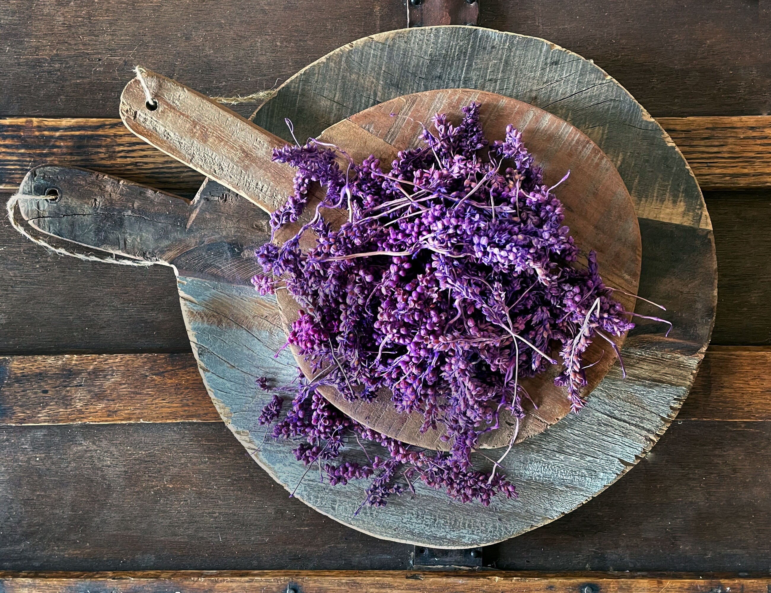 Purple flowers on a wooden board against a rustic wooden background