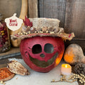 Decorative pumpkin with a top hat and autumnal elements on a rustic background