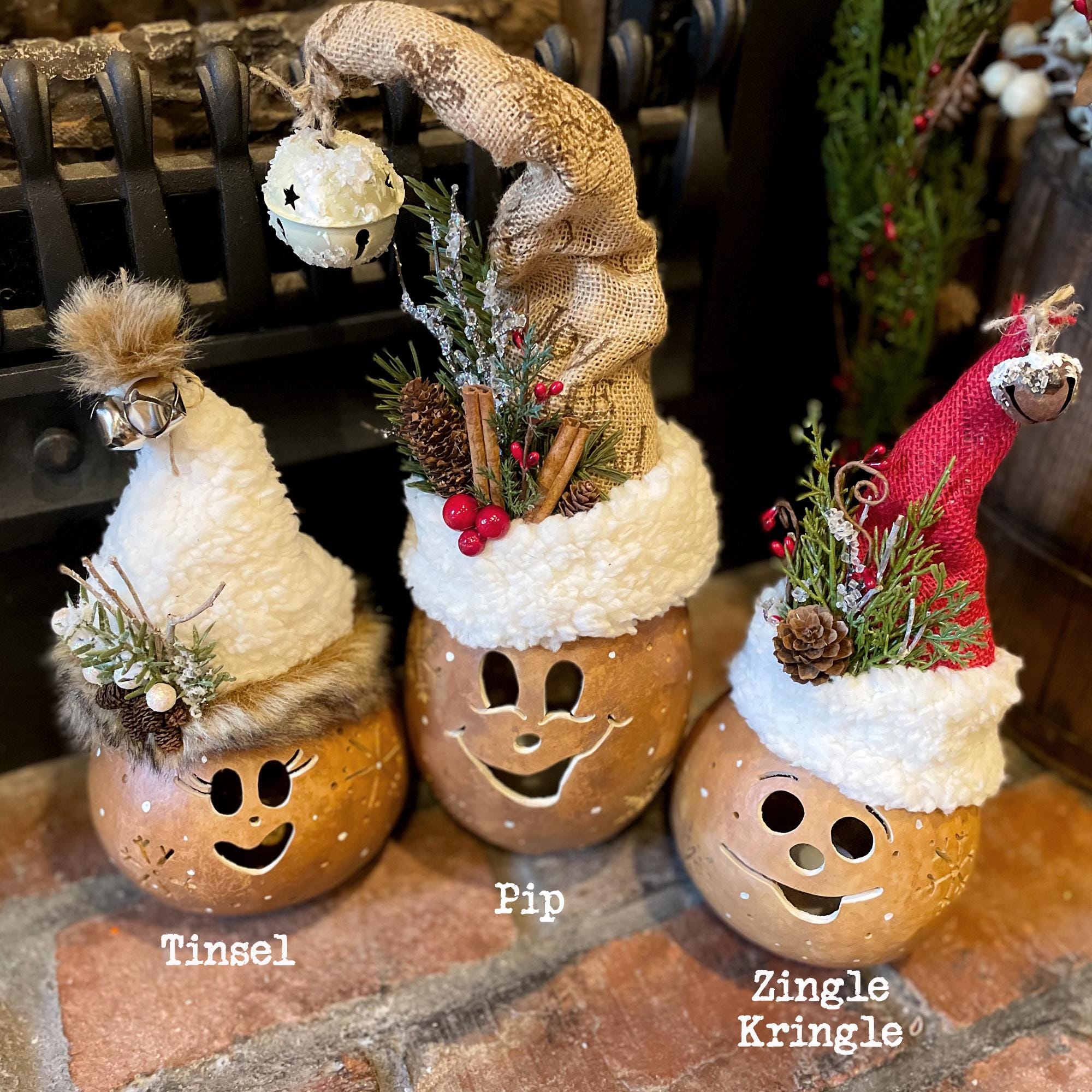 Three decorative bottles with festive hats and faces on a stone surface.