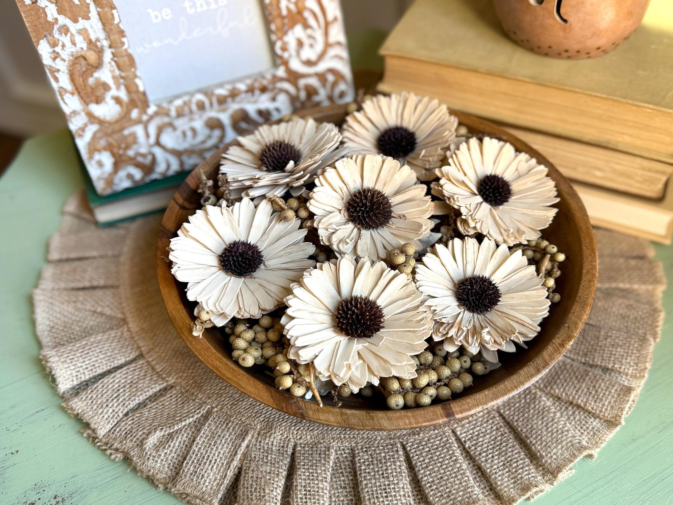 Wooden bowl with decorative white flowers on a textured surface