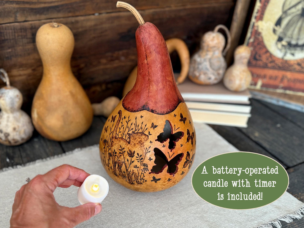 Decorative gourd with butterfly designs on a wooden surface, surrounded by other gourds.