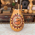 Decorative gourd with mandala design on a textured surface