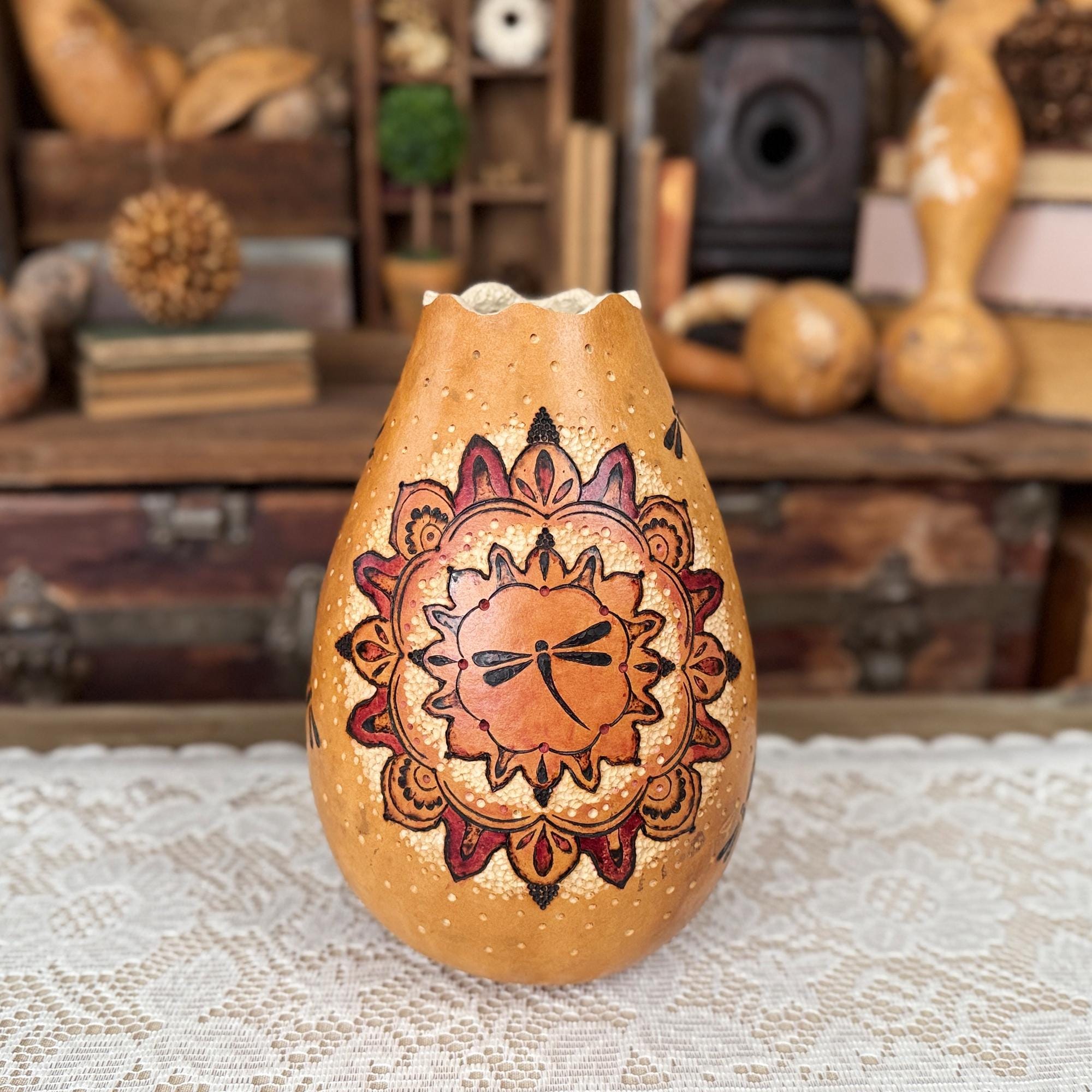 Decorative gourd with mandala design on a textured surface