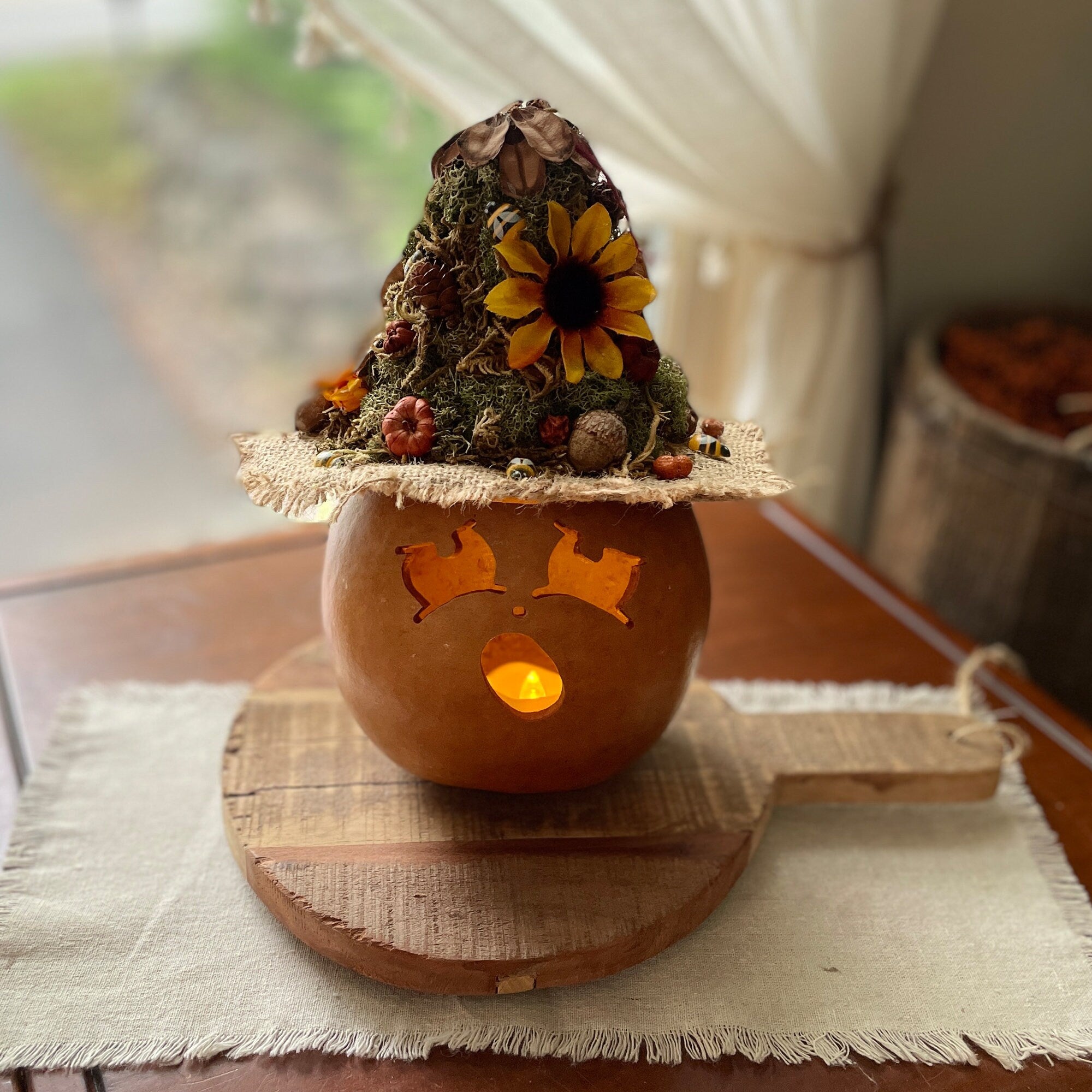 Decorative pumpkin with a witch hat on a wooden board