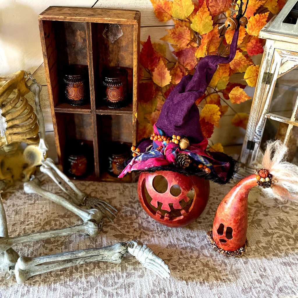 Halloween-themed decor with pumpkins, skeleton, and autumn leaves.