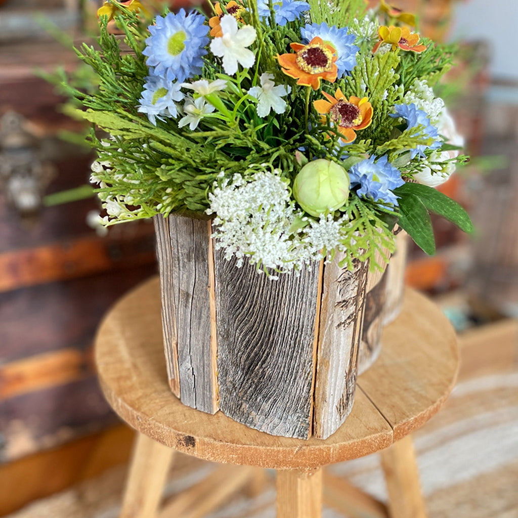 Bouquet of flowers in a rustic wooden box on a wooden stool