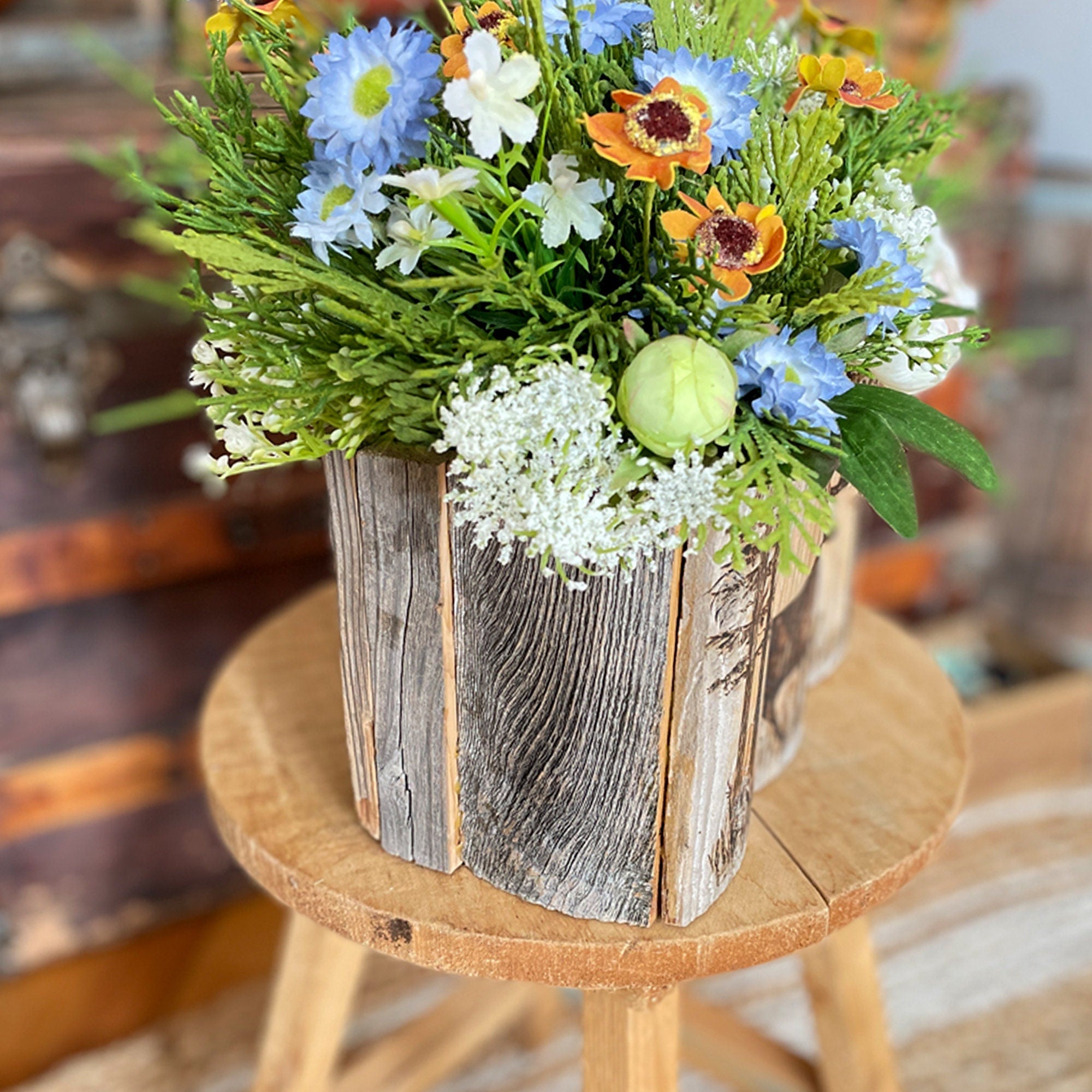 Bouquet of flowers in a rustic wooden box on a wooden stool