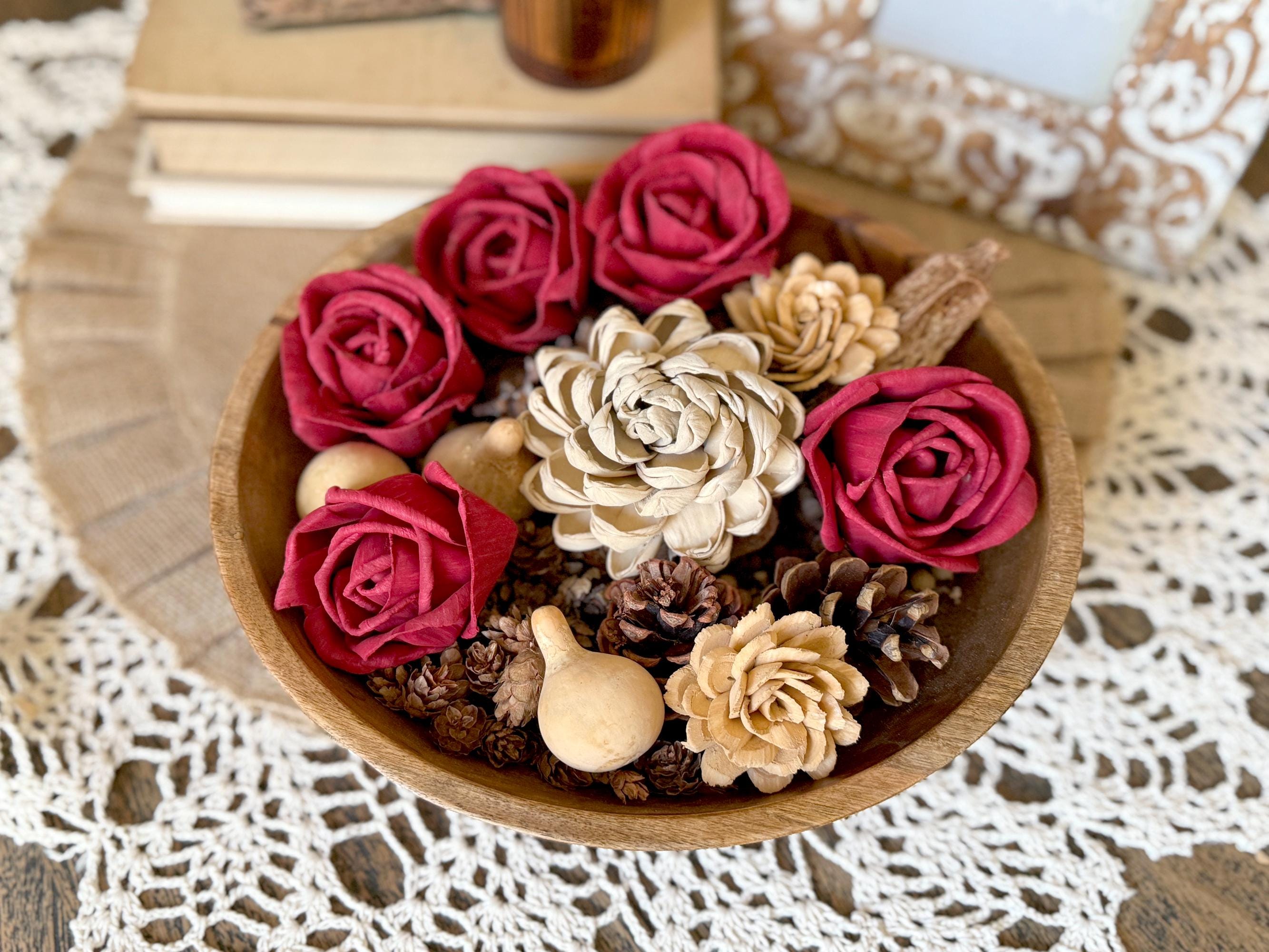 Wooden bowl with red and beige flowers on a lace tablecloth