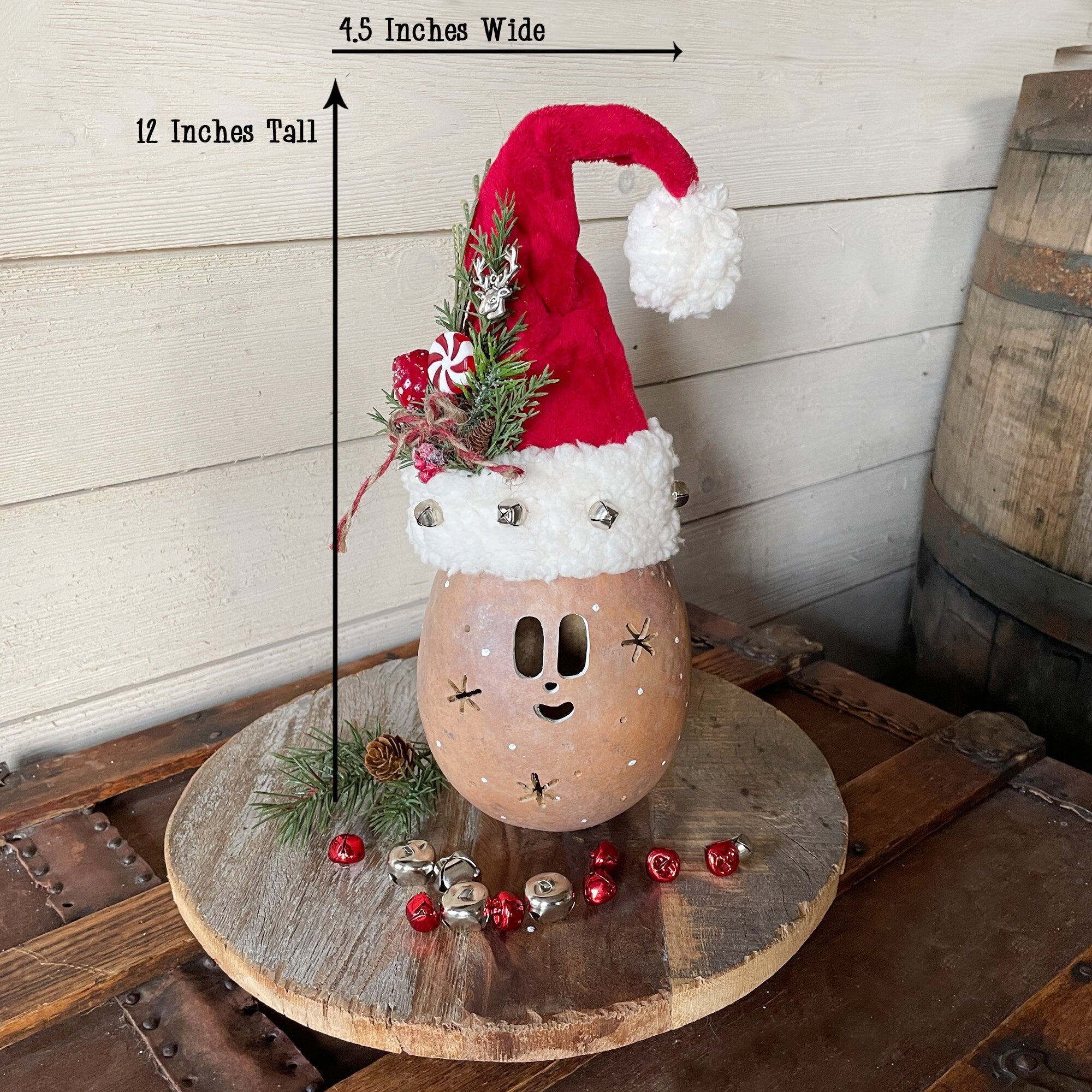 Decorative gourd with a Santa hat on a wooden surface, with measurements indicated.