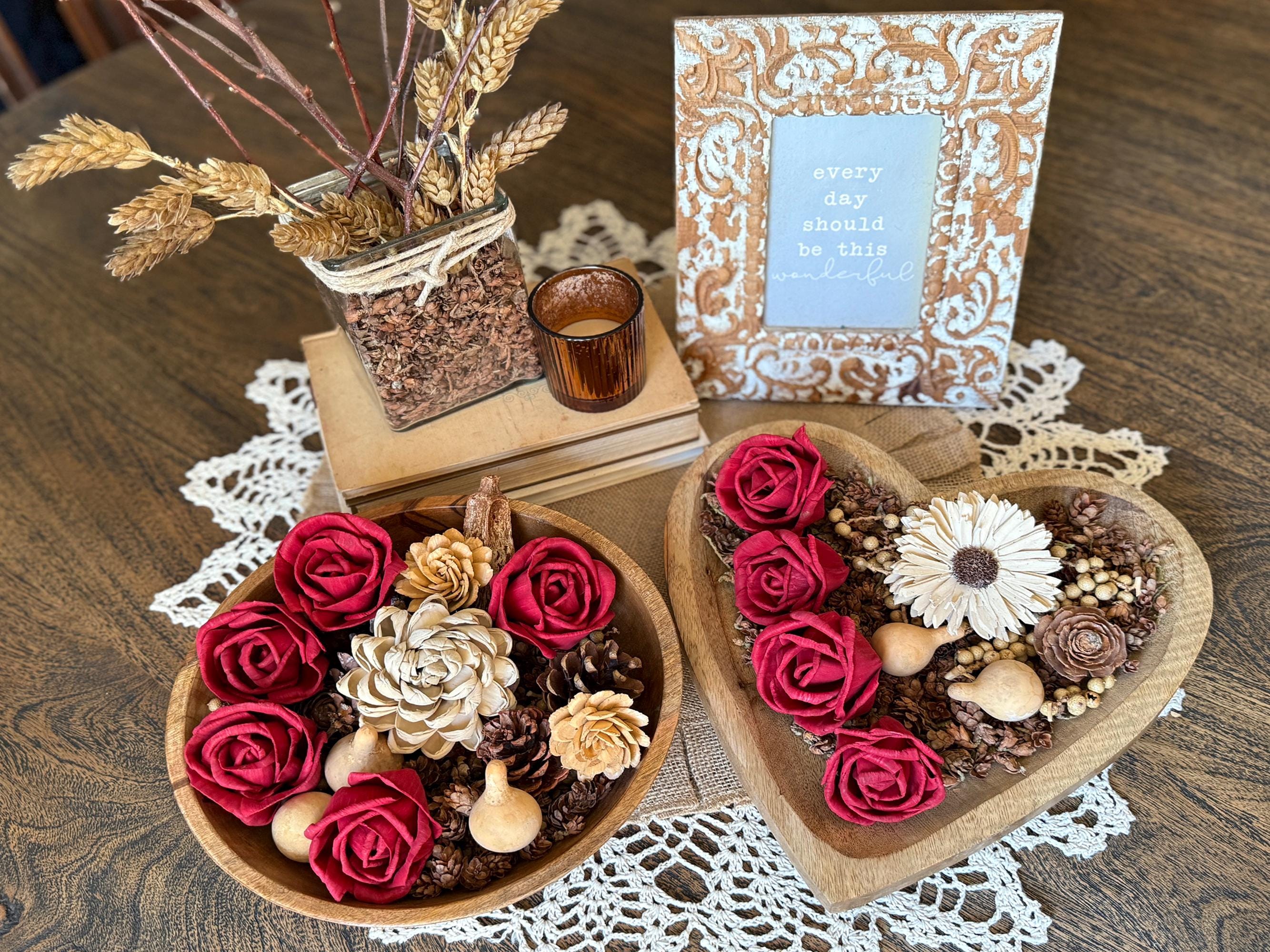 Decorative heart-shaped bowl with flowers on a wooden table