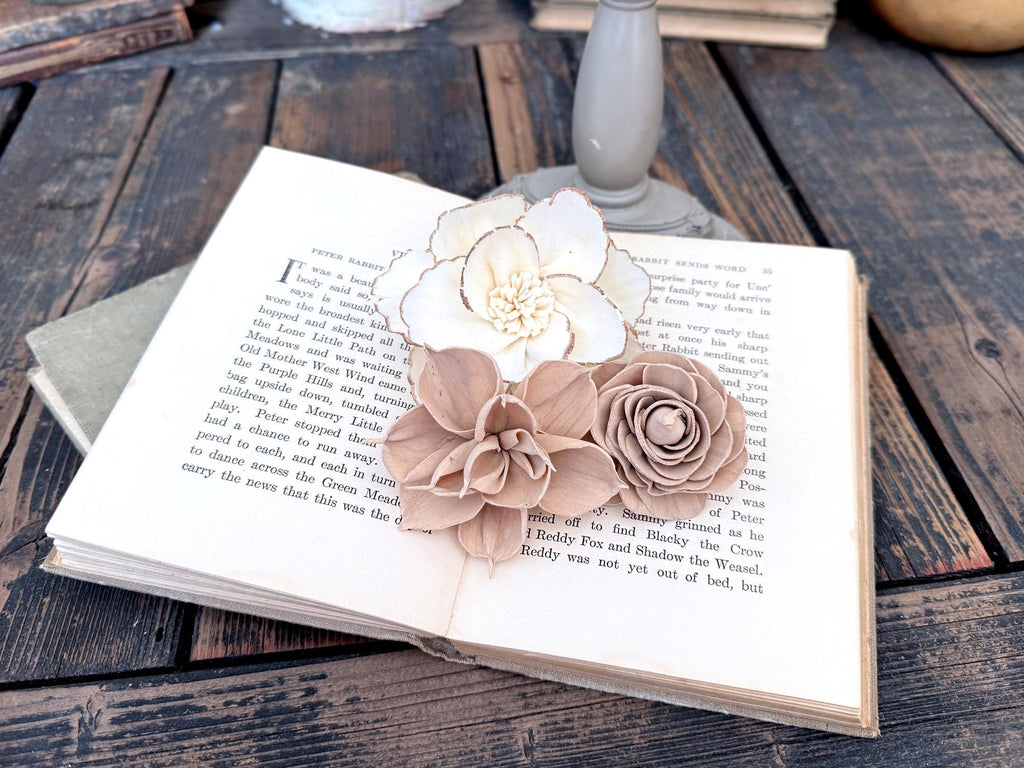 Decorative flowers on an open book with a rustic wooden background