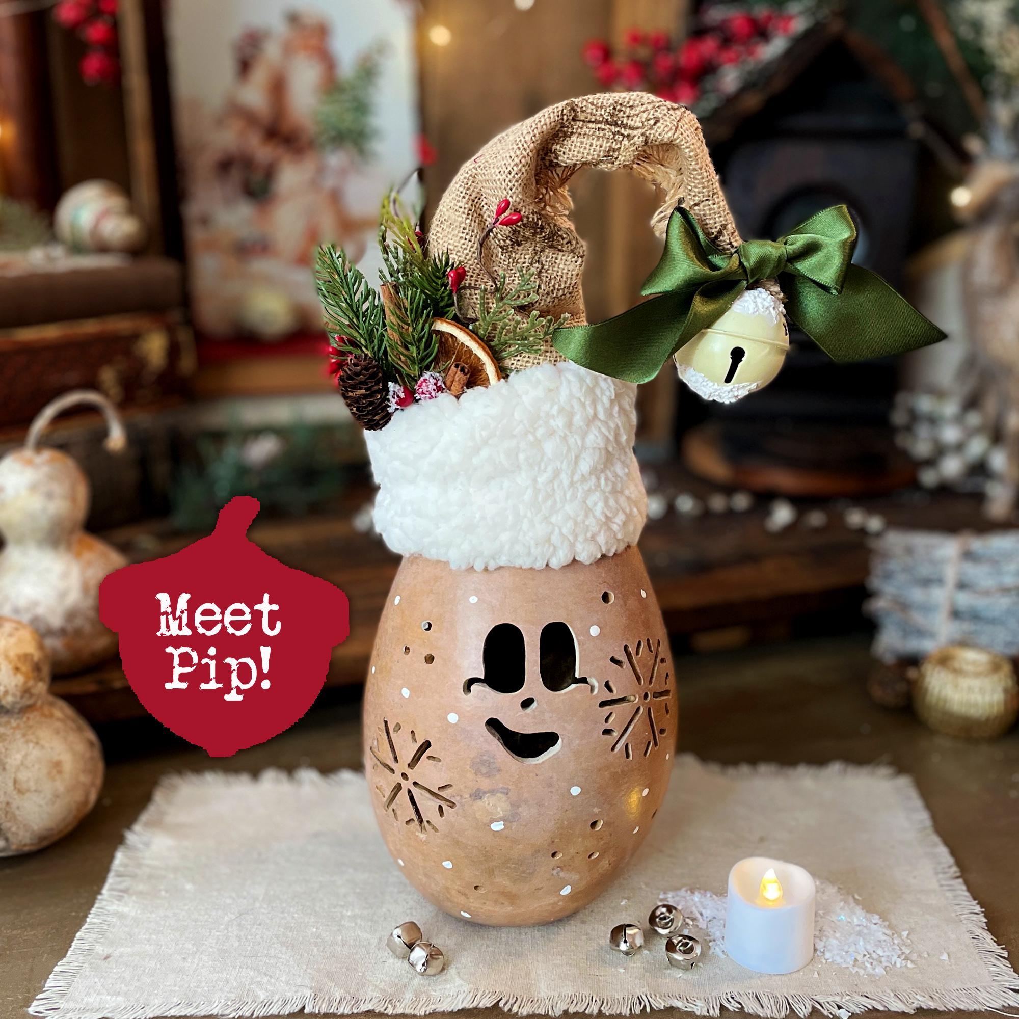 Decorative lantern with a face, Santa hat, and green bow, featuring a candle and small bell on a textured surface.