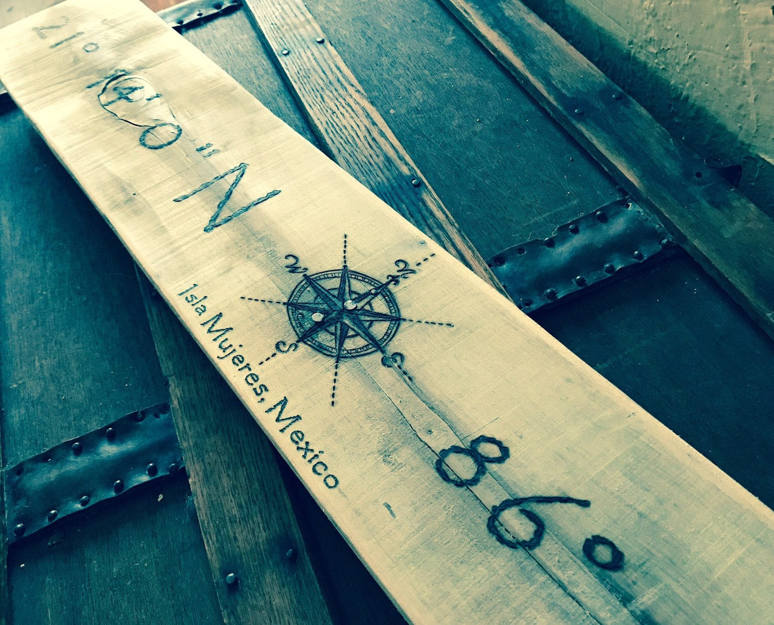 Wooden ruler with compass rose and text on a wooden surface