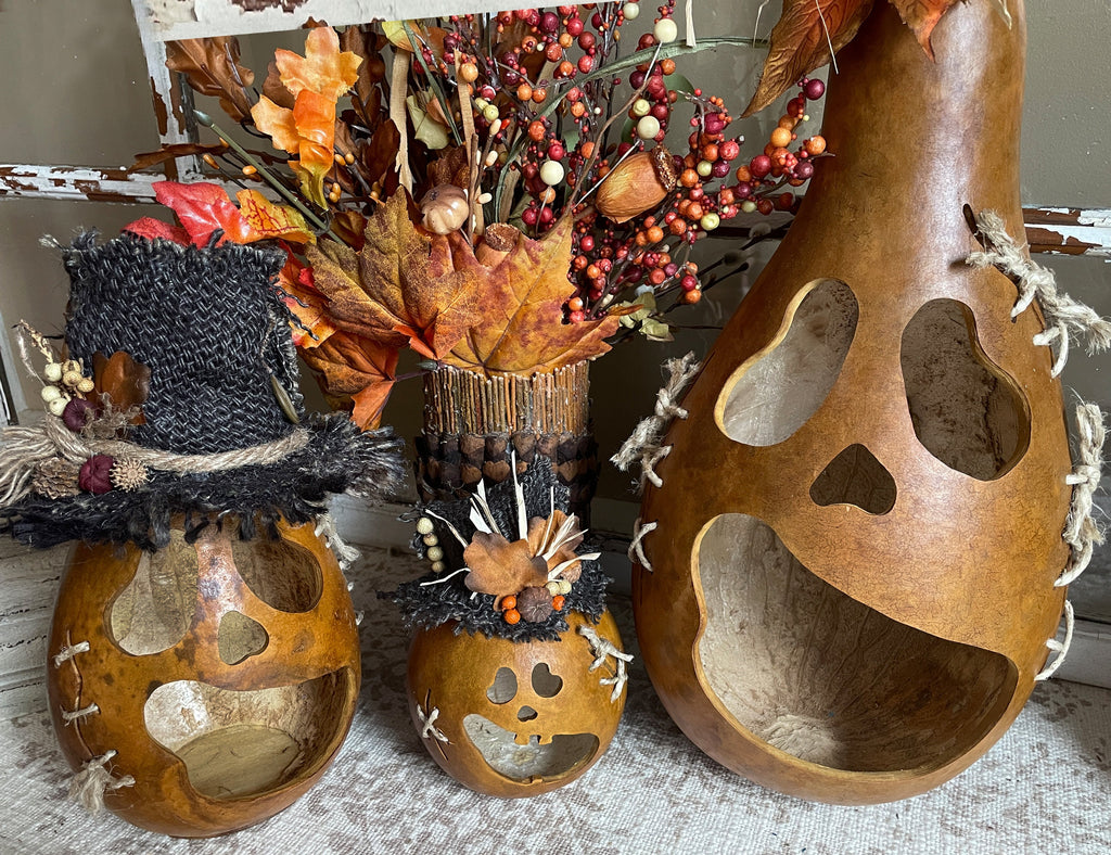 Decorative gourds with autumn leaves and berries on a textured surface