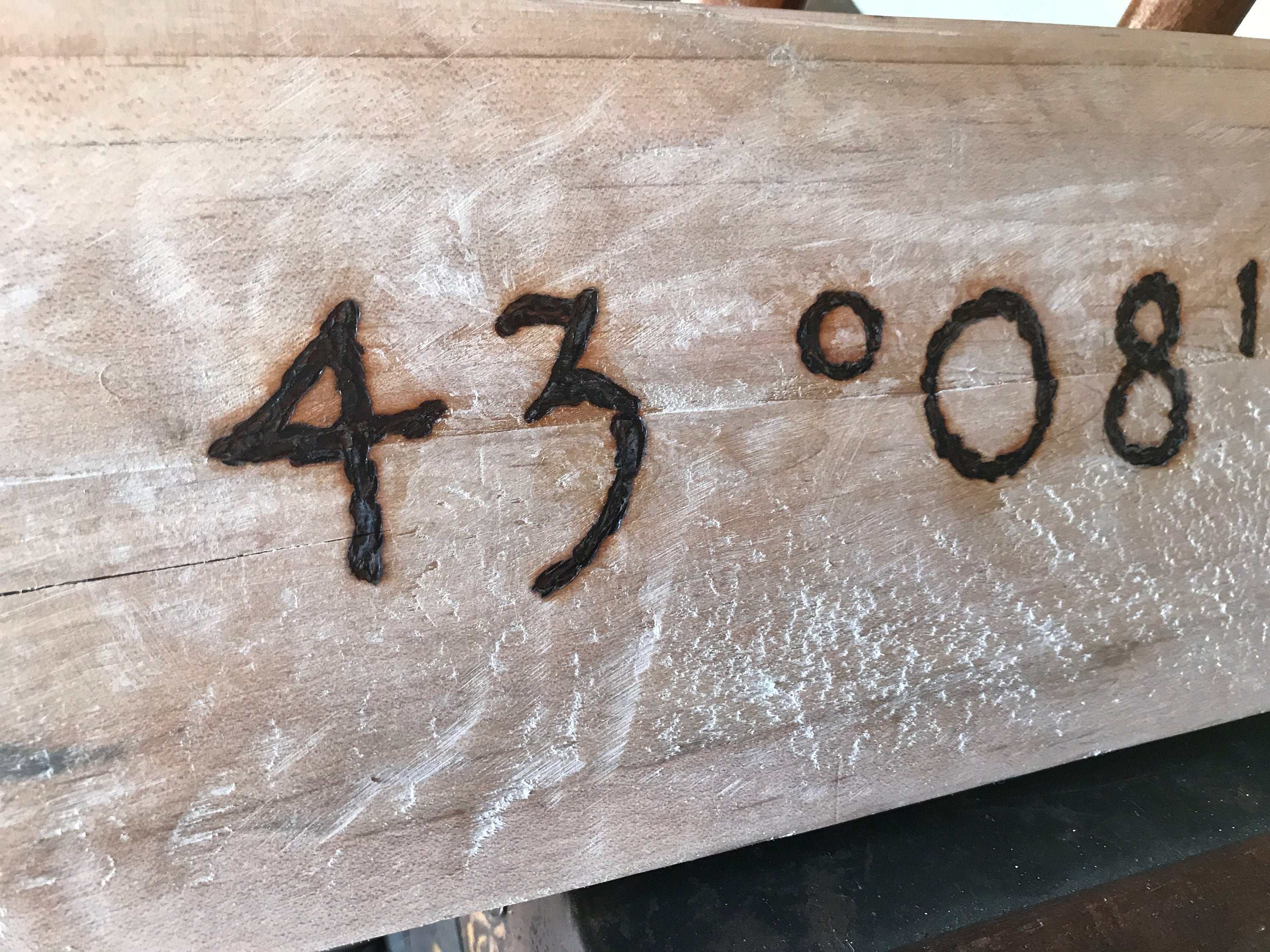 Wooden board with numbers '43 08' carved into it
